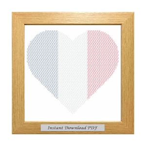 May include: A framed cross-stitch pattern of a heart shaped French flag in blue, white, and red. The frame is light wood and the text "Instant Download PDF" is on a small plaque below the image.