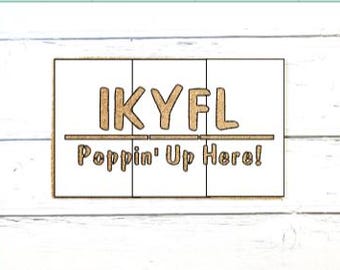May include: A rectangular doormat with a white background and a tan, textured border. The text IKYFL is printed in large, tan, block letters above a horizontal line, with the text Poppin' Up Here! printed in smaller tan letters below the line.