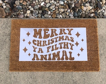 May include: A brown doormat with the text "Merry Christmas Ya Filthy Animal" in white, stylized lettering.