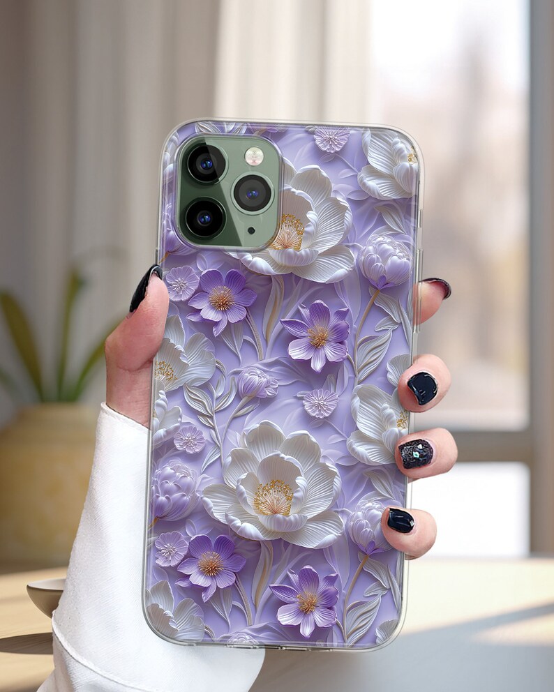 May include: A clear phone case with a 3D floral design. The flowers are white and purple with a textured, embossed look. The case is designed for an iPhone.