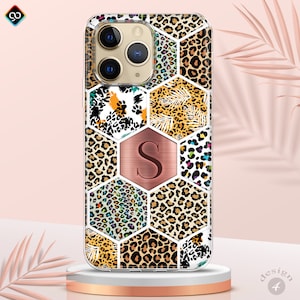 May include: A clear phone case with a geometric pattern of different leopard prints in shades of brown, black, white, pink, and blue. The case has a rose gold hexagon with the letter "S" in the center.
