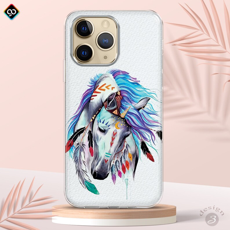 Op de afbeelding: Een transparante telefoonhoes met een witte achtergrond en een kleurrijke aquarel-illustratie van twee paarden met veren en tribale markeringen.