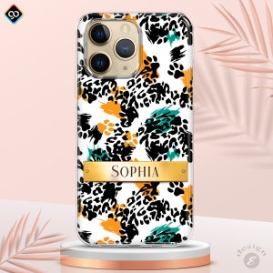 May include: A clear phone case with a white background and a black, green, and orange leopard print design. The case has a gold nameplate with the name "Sophia" on it.