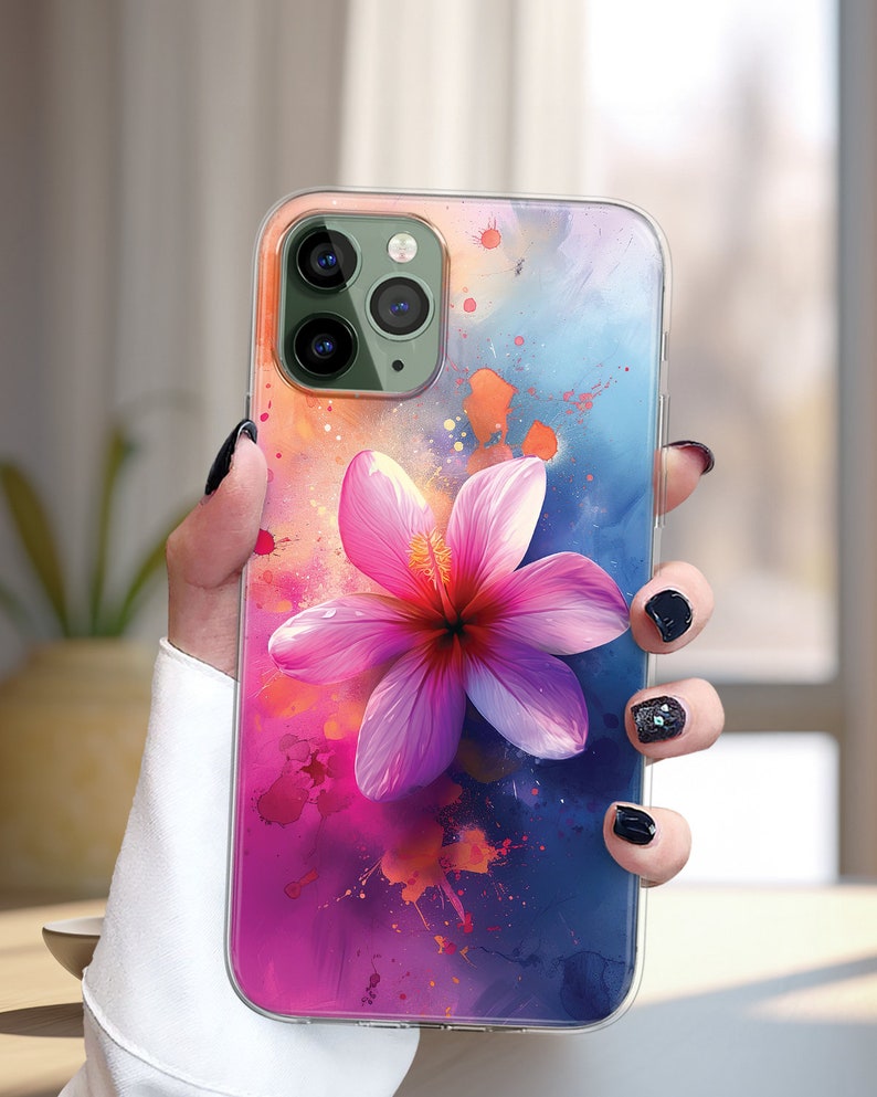 May include: A clear phone case with a pink flower design. The background is a watercolor-style design with blue, pink, and orange colors.