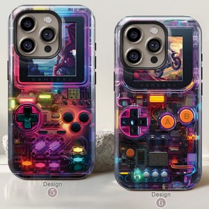 May include: Two clear phone cases with a retro video game design. Each case features a colorful, illuminated circuit board design with a D-pad, buttons, and a screen displaying a graphic. The text "GAME BOX" is visible on the screen.
