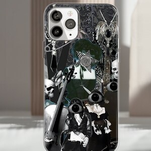 Puede incluir: Funda transparente para tel&eacute;fono con un dise&ntilde;o de collage que presenta im&aacute;genes g&oacute;ticas en blanco y negro. El dise&ntilde;o incluye calaveras, un violonchelo y figuras con grandes rasgos oculares. La funda est&aacute; dise&ntilde;ada para un smartphone.