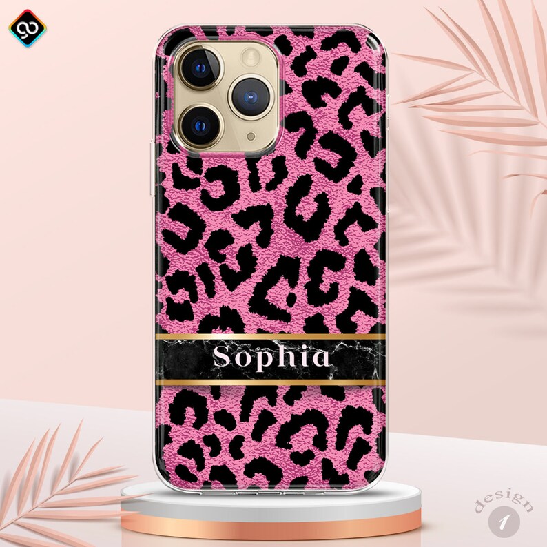 May include: Pink iPhone case with a black leopard print design and a black marble band with the name "Sophia" in gold lettering.