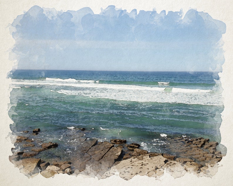May include: A watercolor painting of a seascape with blue sky, white clouds, and turquoise water with white waves crashing on the shore. The foreground shows rocky terrain.