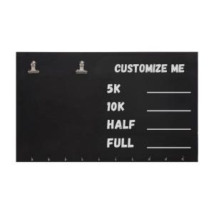 Pode incluir: Um quadro de exibição retangular preto com dois clipes de metal prateado no topo e uma fileira de pequenos ganchos na parte inferior. O quadro exibe o texto branco CUSTOMIZE ME seguido de 5K, 10K, HALF e FULL, cada um com uma linha.