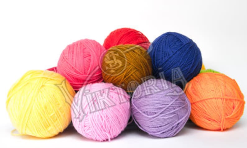 May include: A collection of colorful yarn balls in shades of yellow, pink, red, blue, orange, purple, and brown. The yarn is tightly wound, suggesting it's ready for knitting or crocheting projects. The balls are arranged in a pile against a white background.