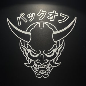 Könnte beinhalten: Eine Schwarzweißillustration eines japanischen Dämons mit Hörnern und einem grimmigen Ausdruck. Der Text "パツクオウ" steht über dem Dämon.