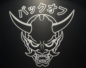 May include: A black and white illustration of a Japanese demon with horns and a fierce expression. The text "パツクオウ" is written above the demon.