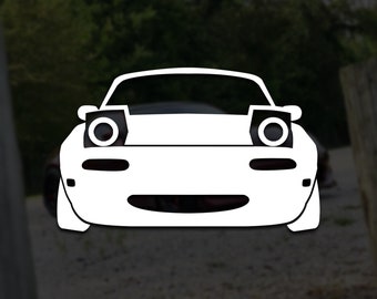 Può includere: Silhouette bianca di un'auto con fari, che ricorda un viso di cartone animato.
