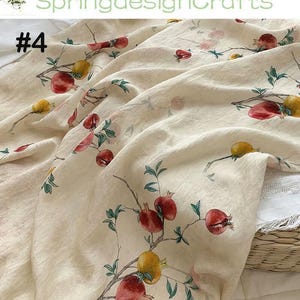 Peut inclure: Tissu cr&egrave;me avec un motif r&eacute;p&eacute;t&eacute; de grenades rouges et jaunes, ainsi que des feuilles vertes et des branches brunes. Le tissu est drap&eacute;, avec le num&eacute;ro "#4" visible en haut &agrave; gauche et le texte "SpringdesignCrafts" en haut.