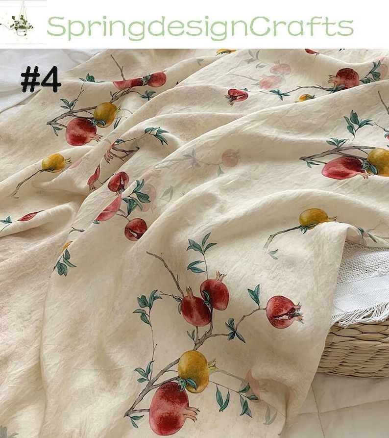 Peut inclure: Tissu cr&egrave;me avec un motif r&eacute;p&eacute;t&eacute; de grenades rouges et jaunes, ainsi que des feuilles vertes et des branches brunes. Le tissu est drap&eacute;, avec le num&eacute;ro "#4" visible en haut &agrave; gauche et le texte "SpringdesignCrafts" en haut.