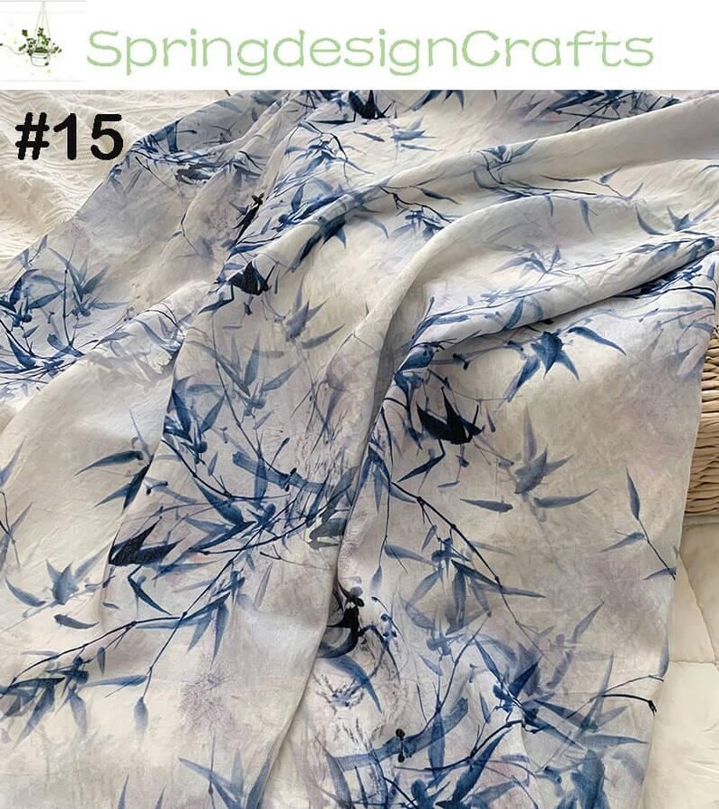 Peut inclure: Tissu blanc avec un motif de feuilles de bambou bleues. Le tissu a un effet aquarelle avec le texte "SpringdesignCrafts" et le num&eacute;ro "#15" dans le coin sup&eacute;rieur gauche.