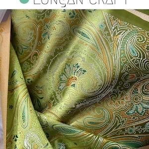 May include: Green paisley fabric with gold and silver accents. The fabric has a textured, woven look.