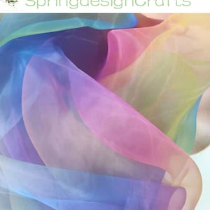 May include: A close-up of flowing, sheer fabric in a rainbow of colors, including pink, blue, yellow, and purple. The fabric is layered and creates a soft, ethereal effect. The text "SpringdesignCrafts" is in the upper left corner.