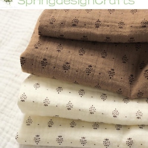 May include: A stack of folded fabric in shades of brown and cream. The fabric is patterned with small, dark floral motifs. The text "SpringdesignCrafts" is visible in the upper left corner.