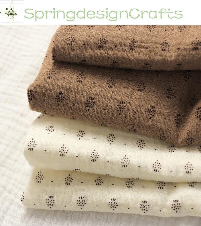 May include: A stack of folded fabric in shades of brown and cream. The fabric is patterned with small, dark floral motifs. The text "SpringdesignCrafts" is visible in the upper left corner.