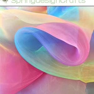 May include: A close-up of flowing, sheer fabric in a spectrum of colors, including pink, blue, yellow, and purple. The fabric is layered and creates a soft, ethereal effect. The text "SpringdesignCrafts" is in the upper left corner.