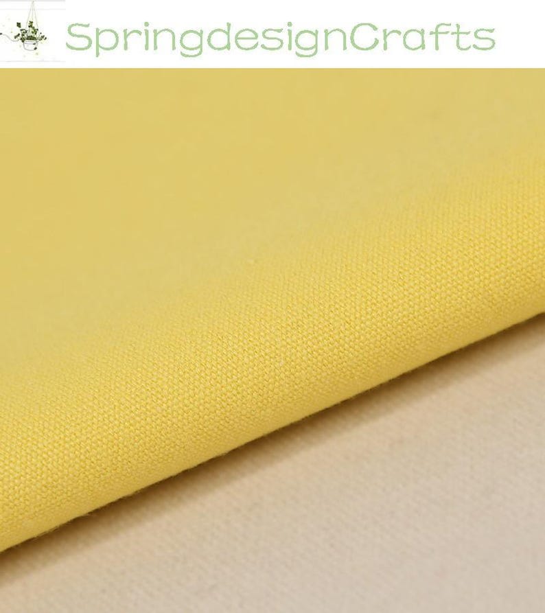 May include: A piece of solid light yellow fabric with a visible woven texture. The textile features a consistent, plain weave pattern throughout the material. The text SpringdesignCrafts is displayed in green at the top of the image.