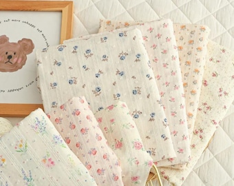 May include: A collection of floral patterned fabrics in various colors, including pink, blue, and lavender. The fabrics are arranged in a fan shape, showcasing different designs and textures. The text "SpringdesignCrafts" is visible at the top.