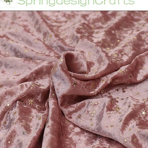 May include: Dusty rose velvet fabric with gold star accents. The fabric is draped, showing the texture and sheen of the material. The text "SpringdesignCrafts" is in the upper left corner.