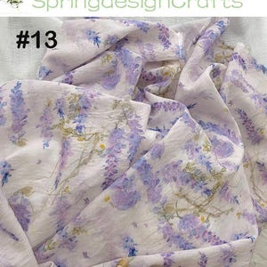Peut inclure: Tissu blanc avec un motif floral &agrave; l'aquarelle de fleurs de glycine violettes et bleues. Le tissu a un drap&eacute; doux et fluide. Le texte "#13" est visible. Le nom de la boutique "SpringdesignCrafts" est &eacute;galement visible.