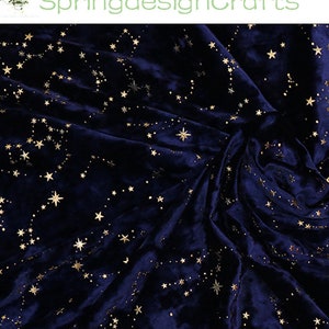 May include: Dark blue velvet fabric with a constellation pattern in gold. The fabric is draped, creating soft folds and shadows. The text "SpringdesignCrafts" is in the upper left corner.