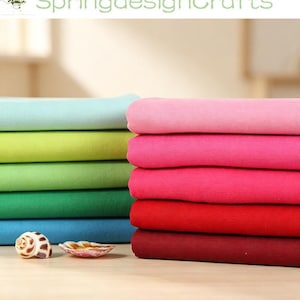 May include: Two stacks of folded fabric in a gradient of colours. The left stack features light blue, lime green, grass green, and dark blue. The right stack features light pink, hot pink, magenta, red, and deep burgundy. Two seashells sit in front.