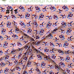 Peut inclure: Un tissu &agrave; motifs avec des oiseaux bleus et des motifs floraux violets, orange et bleus sur un fond brun clair. Le texte "#1" est visible en haut &agrave; gauche, et "SpringdesignCrafts" est en haut au centre.