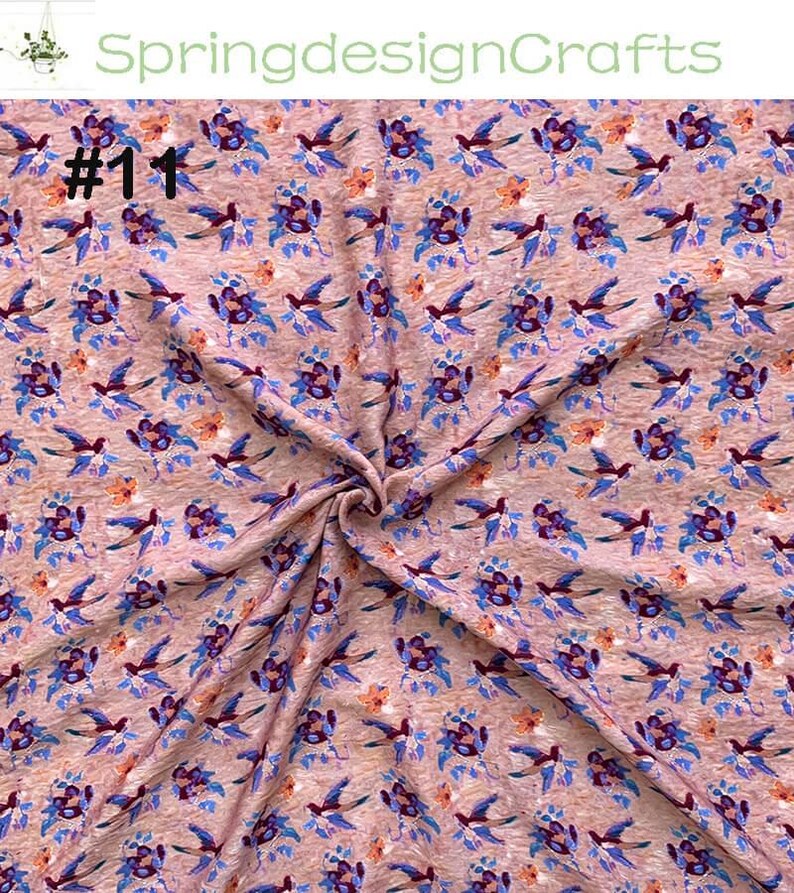 Peut inclure: Un tissu &agrave; motifs avec des oiseaux bleus et des motifs floraux violets, orange et bleus sur un fond brun clair. Le texte "#1" est visible en haut &agrave; gauche, et "SpringdesignCrafts" est en haut au centre.