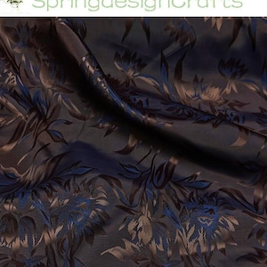 May include: Dark navy fabric with a floral pattern in shades of blue and brown. The fabric has a subtle sheen, and the floral design is intricately detailed. The text "SpringdesignCrafts" is visible in the upper left corner.