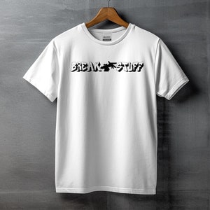 May include: White t-shirt with black text that reads "BREAK STUFF" in a stylized font.
