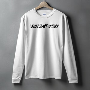 Pode incluir: Camiseta branca de manga comprida com texto preto que diz "BREAK STUFF" em uma fonte de estilo graffiti.