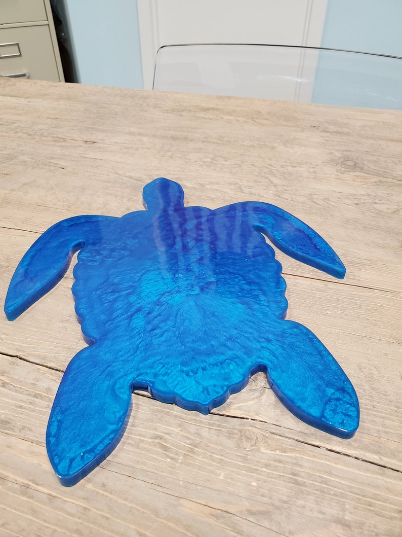 May include: A blue resin turtle shaped serving tray. The tray is made of resin and has a shiny, glossy finish.
