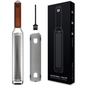 Könnte beinhalten: Eine silberne Reibe mit einem Holzgriff und einer schwarzen Reinigungsbürste. Die Reibe ist mit "RED SALT" und "STAINLESS STEEL" beschriftet. Die Verpackung enthält den Text "ZESTER REIBE / GRATER PROFESSIONAL SERIES" und "FOLLOW US".