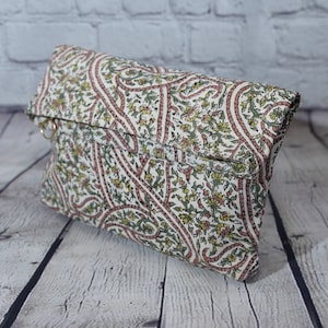 Può includere: Una pochette bianca con un motivo paisley in tonalità rosa, verde e giallo. La borsa ha una chiusura a lembo e un anello in metallo dorato.