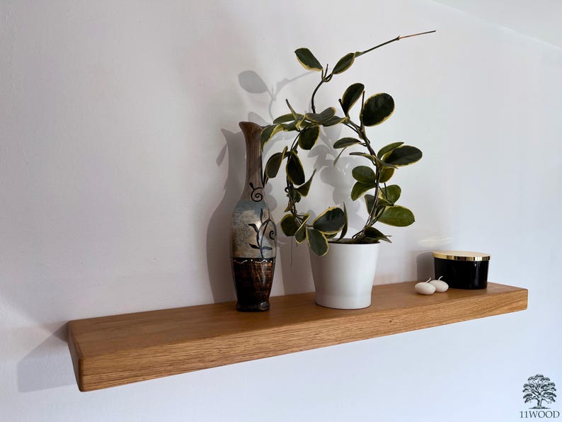 Pu&ograve; includere: Uno scaffale in legno con un vaso, una pianta in vaso e un portacandele nero. Lo scaffale &egrave; realizzato in legno naturale e ha un aspetto rustico.