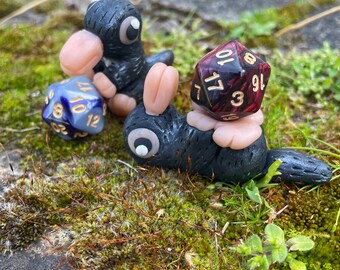 Pequeñas criaturas mágicas, robando dados de D&D, sentándose y acostándose, Dados de diferentes colores.