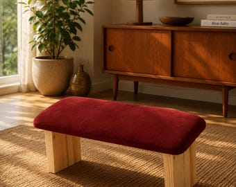 Diese gepolsterte Meditationsbank mit blauem Bezug und Holzbeinen bietet eine stabile Sitzfläche für die Meditation.