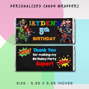 May include: Two personalised candy bar wrappers featuring a superhero theme. The top wrapper has a black background with colourful text that reads "JAYDEN'S 5th BIRTHDAY". The bottom wrapper has a black chalkboard background with the text "Thank You for making my Birthday Party Super!" and a red and yellow "POW!" and "BANG!" graphic. Both wrappers feature images of popular superheroes.