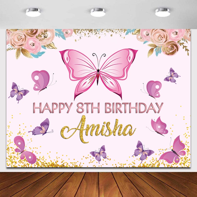 May include: Pink and purple butterfly themed birthday backdrop with gold glitter and the text "Happy 8th Birthday Amisha".