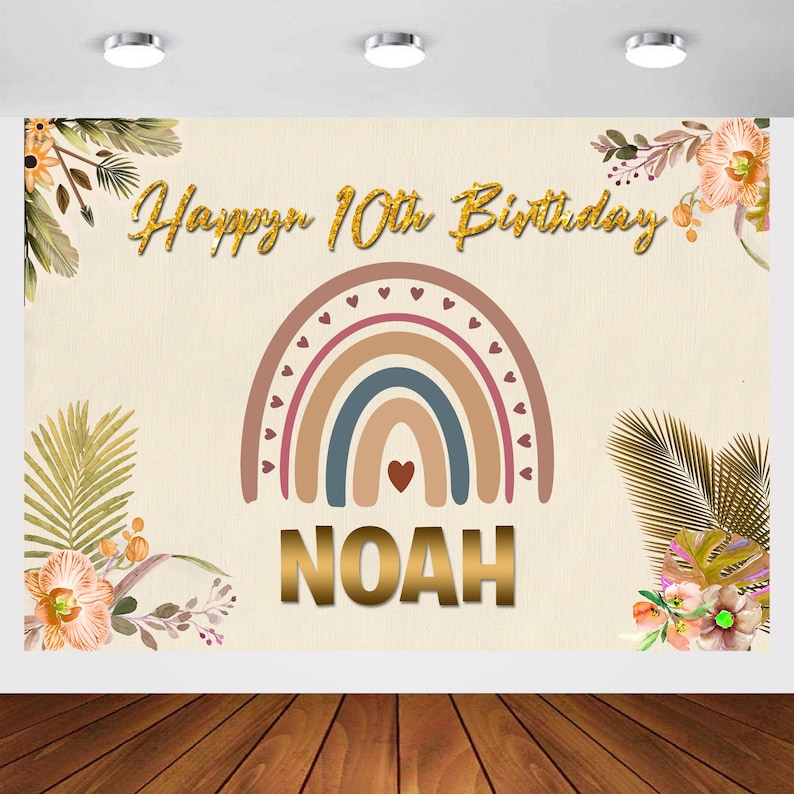 May include: A beige background with a rainbow arch in shades of brown, blue, and pink. The rainbow is decorated with small pink hearts. The text "Happy 10th Birthday" is written in gold glitter letters. The name "NOAH" is written in gold letters below the rainbow.