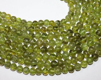 May include: A strand of round, green gemstone beads. The beads are smooth and have a slightly translucent appearance.
