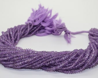 May include: A strand of amethyst beads, approximately 4mm in size, with a light purple color. The beads are faceted and have a slight sparkle. The strand is approximately 16 inches long and is strung on a clear elastic cord.
