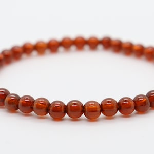 May include: A brown gemstone bracelet with round beads.