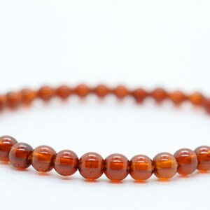 May include: A brown beaded bracelet with round beads.