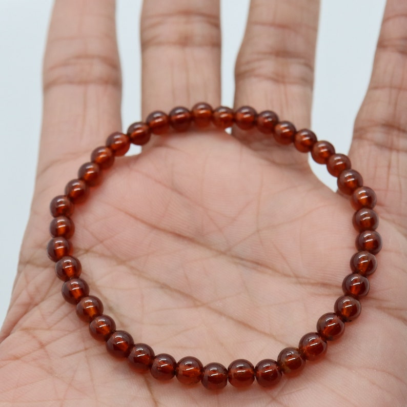 May include: A brown gemstone bracelet with round beads. The bracelet is made of natural stones and is approximately 7 inches in length.